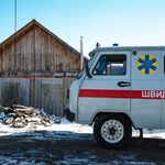 Foto: WHO/Blink Media - Brendan Hoffman Unter blauem Himmel steht ein weißer Krankentransporter.